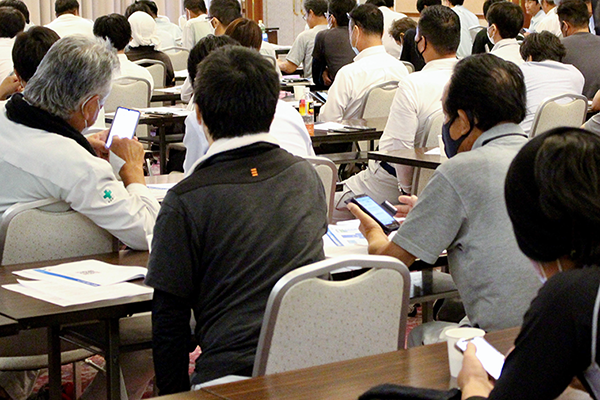 スマホを手に説明に聞き入る参加者たち（現場Plus説明会）