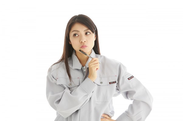 考え込む作業着姿の女性