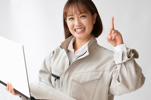PCを持って指をあげる笑顔の女性