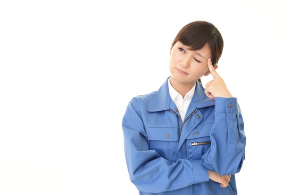 考える作業着姿の女性