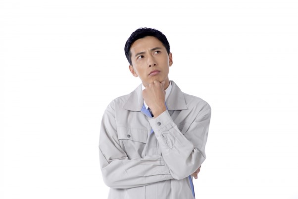 考え込む作業着姿の男性