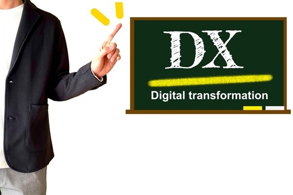黒板に書かれたDXを指すビジネスパーソン