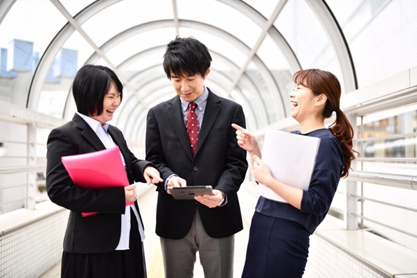 タブレットを見ながら笑う営業チーム