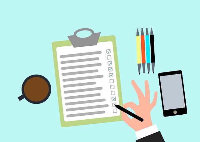 チェックリストに記入する手元と、ペンやスマホ