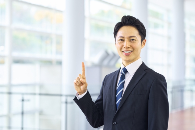 笑顔で指を立てるビジネスパーソン