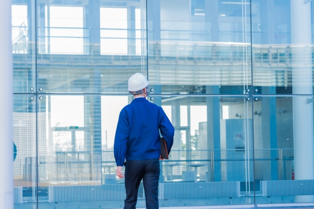 作業服を着た男性の後ろ姿