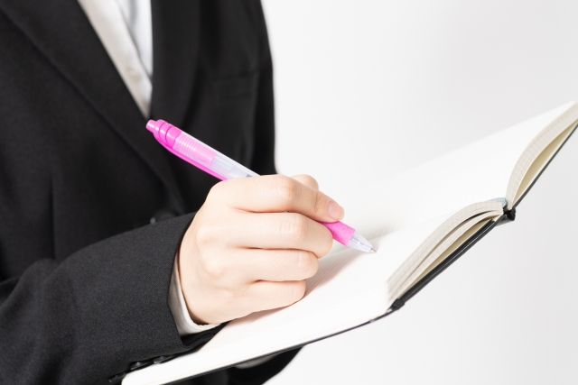 ノートにボールペンで書き込む人