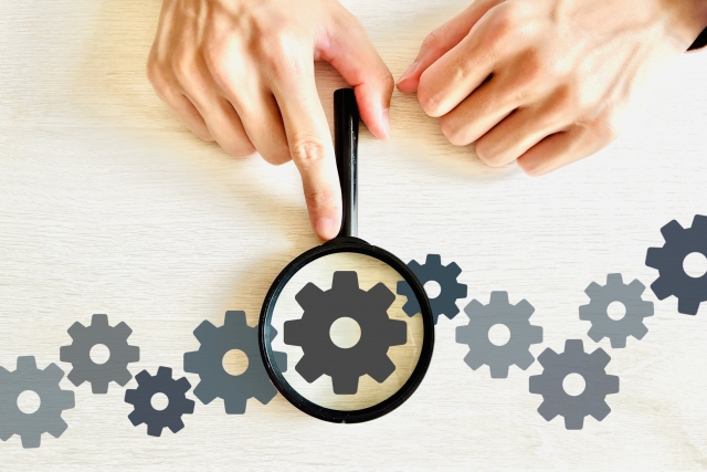 連なる歯車のイラストと虫眼鏡
