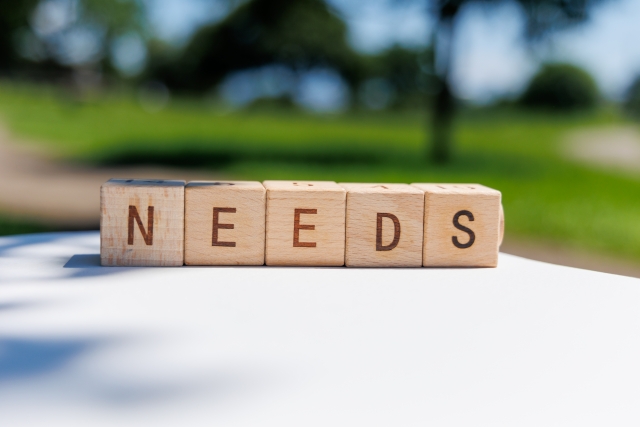 「NEEDS」と印字された木製ブロック