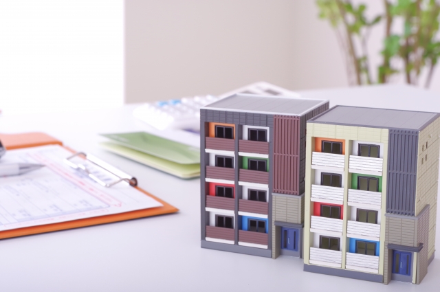 マンションの模型と書類を挟んだバインダー